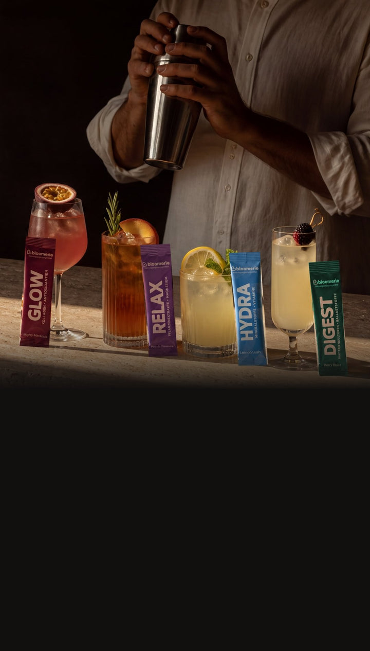 Barkeeper mixt vier bloomerie® Drinks, vor jedem Glas der passende Stick